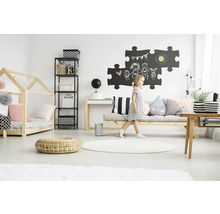 Lichte kinderkamer met houten bed, plank, bureau, bank en spelend kind