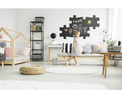 Lichte kinderkamer met houten bed, plank, bureau, bank en spelend kind