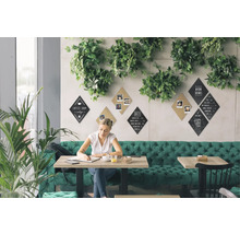 Scène van een helder café met groene decoratie, waar een vrouw aan een tafel zit te schrijven