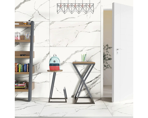 Lichte ruimte met boekenplank, kruk, tafel, lamp en tegels met marmerlook