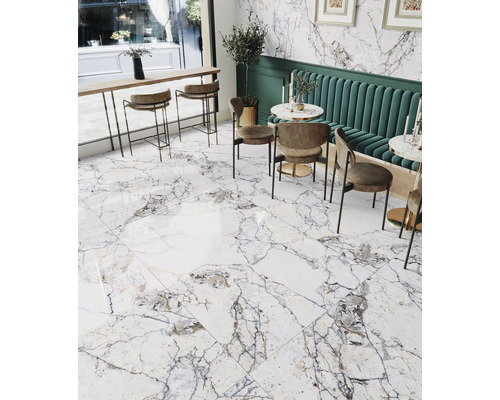 Overzicht van een lichte ruimte met marmerlook vloertegels, zitgelegenheid en decoratieve elementen.