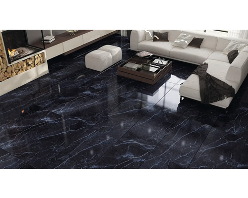 Woonkamer met donkere, glanzende marmeren vloer, open haard en zithoek