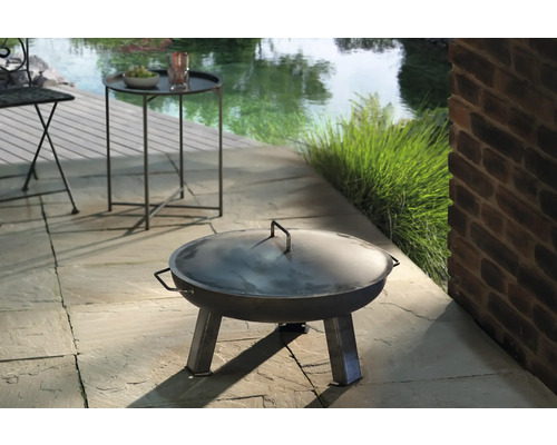 Metalen vuurschaal met deksel op een terras