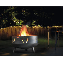 Vuurkorf met vlammotief in een tuin met tafel en stoelen