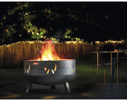 Vuurkorf met vlammotief in een tuin met tafel en stoelen