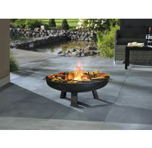 Vuurschaal met gegrild eten op een terras met een tuinvijver