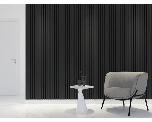 Woonkamer met akoestische panelen aan de wand, een fauteuil en een bijzettafel.