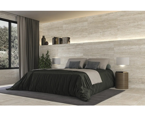 Slaapkamer met wand- en vloertegels in natuursteenlook, bed en nachtkastjes.