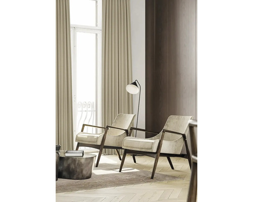 Woonkamer met twee fauteuils, een staande lamp en gordijnen