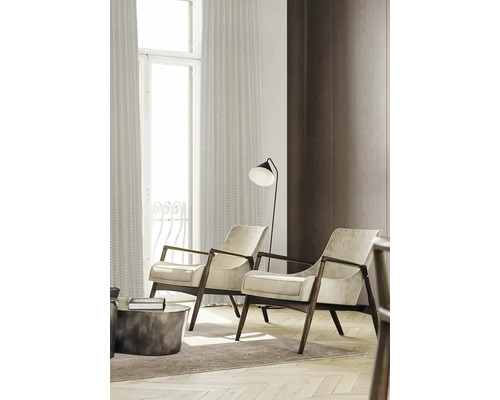 Twee fauteuils met houten frame, vloerlamp en gordijnen in een woonkamer.