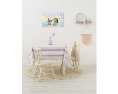 Decoratieve kinderkamer met tafel, stoelen en een muurschildering van Lilo en Stitch.