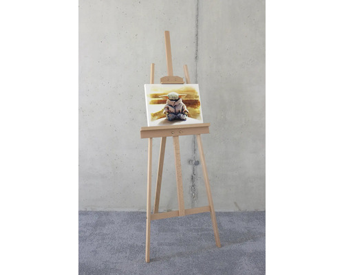 Houten schildersezel met doek en afbeelding van een figuur