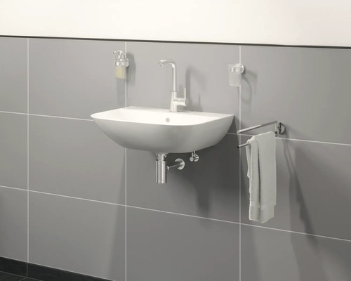 Hangende wastafel met kraan, zeepdispenser, tandenborstelbeker en handdoekhouder voor een grijze muur