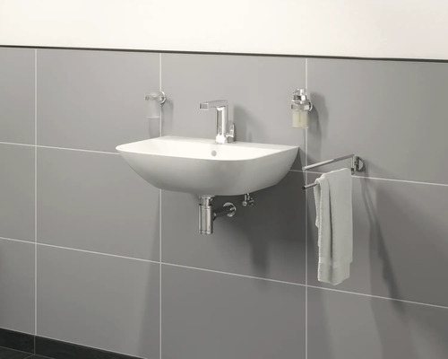 Wastafel met kraan, zeepdispenser, tandenborstelbeker en handdoekhouder aan grijze muur