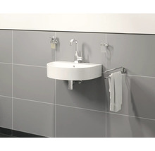 Halfronde wastafel met kraan, zeepdispenser, tandenborstelbeker en handdoekhouder aan een grijze wand