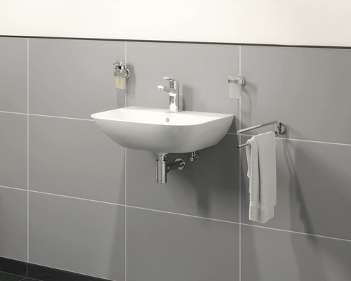 Keramische wastafel met kraan, zeepdispenser, tandenborstelbeker en handdoekhouder in de badkamer