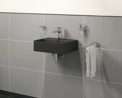 Moderne badkamer met zwarte wastafel, kraan, zeepdispenser en handdoekhouder aan de wand.