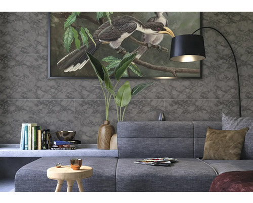 Woonkamer met grijze bank, staande lamp en wandtegels in marmerlook