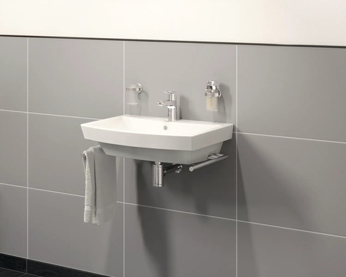 Keramische wastafel met kraan en handdoekhouder aan betegelde wand