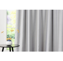 Grijs gordijn voor raam met bijzettafel en decoratie