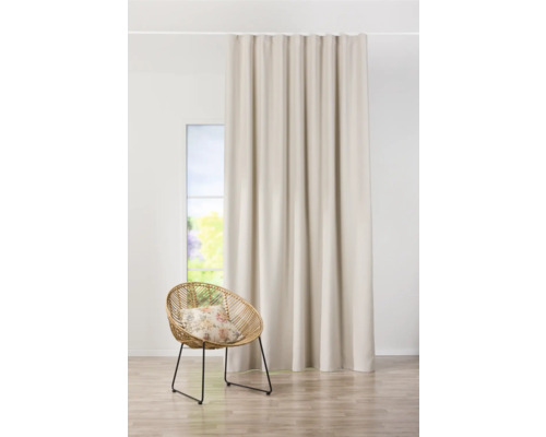 Beige gordijn naast rotan stoel en raam
