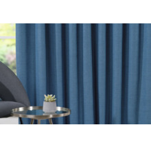 Decoratief blauw gordijn met tafel en plant in pot