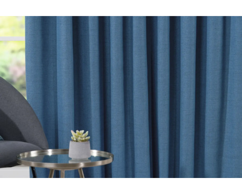 Decoratief blauw gordijn met tafel en plant in pot