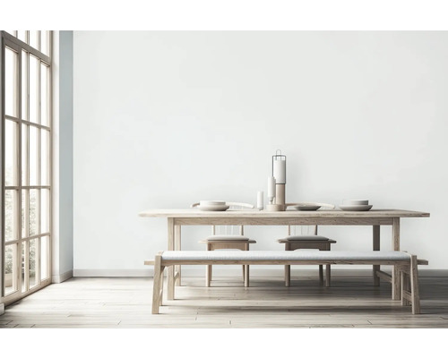 Lichte eetkamer met houten tafel, bank, stoelen en decoratie