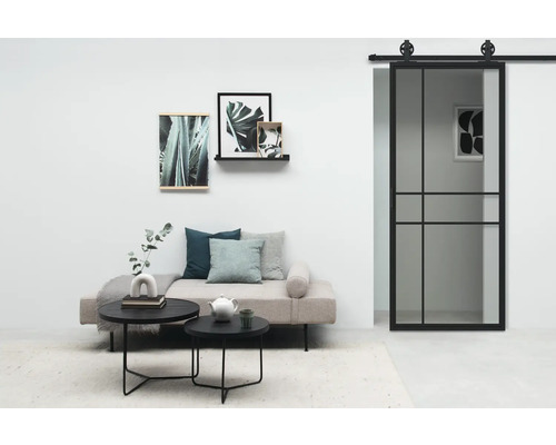Woonkamer met schuifdeur, bank, salontafel en wanddecoraties voor een lichte en georganiseerde sfeer.
