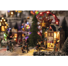 Kerstdorp tafereel met figuren, bomen, carrousel en cadeauwinkel