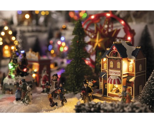 Kerstdorp tafereel met figuren, bomen, carrousel en cadeauwinkel