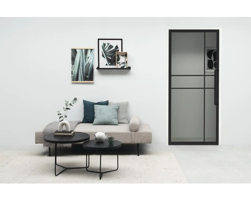 Lichte woonkamer met deur, bank, salontafel en decoratie