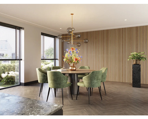 Lichte eetkamer met ronde houten tafel, groene stoelen en houten lambrisering