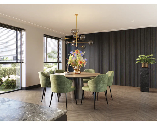 Eetkamer met ronde tafel, groene stoelen en decoratieve verlichting