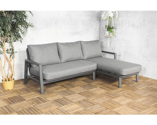 Grijze tuinlounge met drie zitplaatsen en ligfunctie op houten tegels