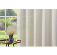Decoratief gordijn voor het raam met plantenarrangement op een klein tafeltje