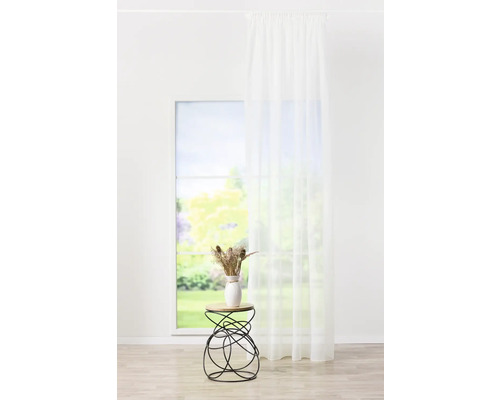 Lichte kamer met raam, gordijn en bijzettafel met decoratie