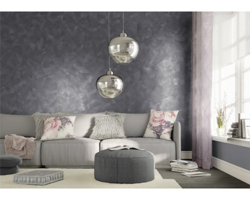 Woonkamer met grijze muurdecoratie, bank, kussens en hanglampen