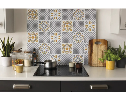 Keukenscène met backsplash met tegelpatroon in geel en grijs boven het kookveld