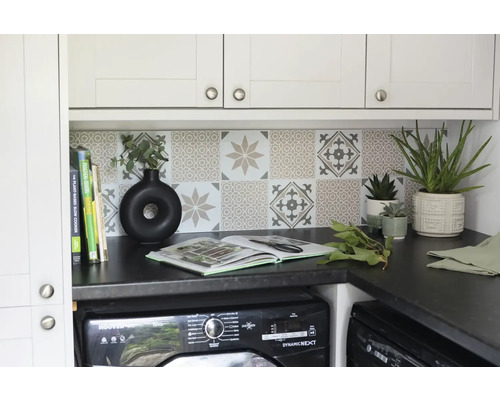 Wasruimte met wasmachine, werkblad, tegels en decoratieve elementen