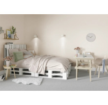 Slaapkamer met bed van houten pallets, bureau en stoel