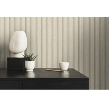 Close-up van een muur met houten lambriseringbehang, een sculptuur, een plant en een kopje op een tafel.