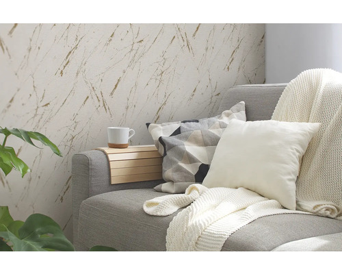 Woonkamer met grijze bank, kussens, deken en wandbehang met marmer effect