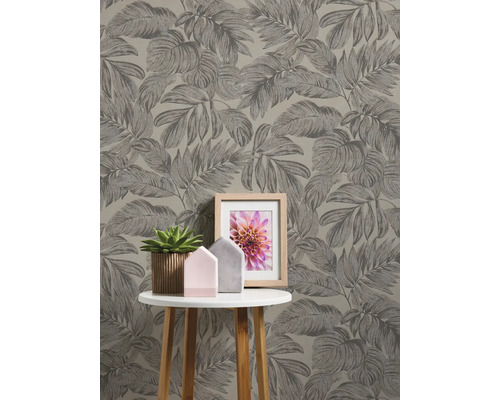 Close-up van een muur met bladerbehang en een tafel met decoratie