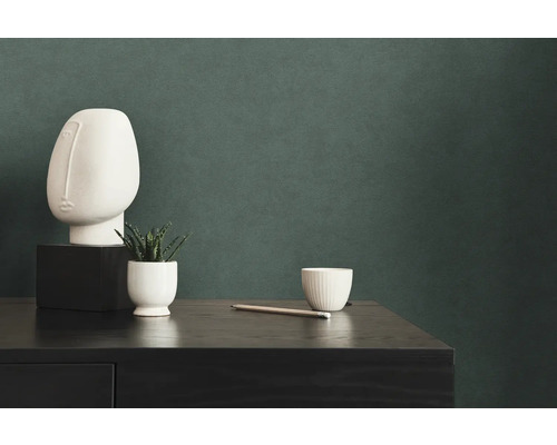 Decoratieve scène met kunsthoofd, plant, beker en potlood op een dressoir.