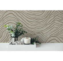 Decoratief behang met golvend patroon als achtergrond voor een arrangement met kaars en planten.