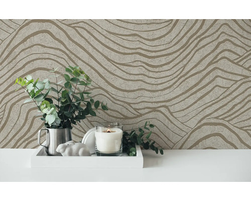 Decoratief behang met golvend patroon als achtergrond voor een arrangement met kaars en planten.