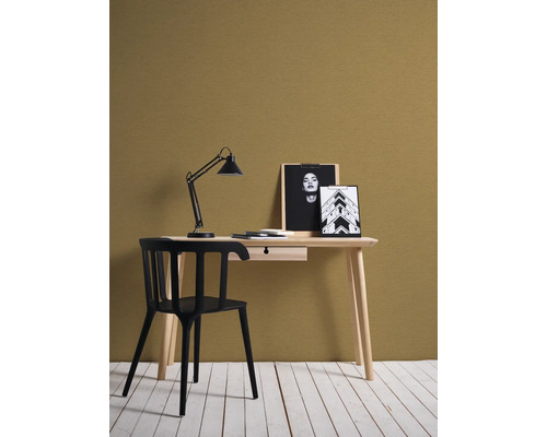 Bureau met bureaulamp, stoel en decoratieve items in een lichte ruimte.