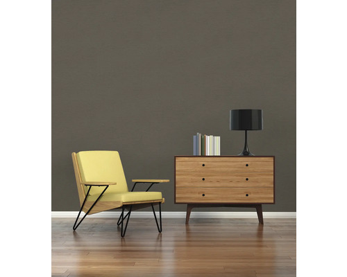 Woonkamer met fauteuil, commode, lamp en boeken