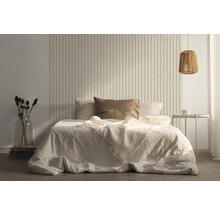 Slaapkamer met bed, nachtkastje en decoratieve wandbekleding